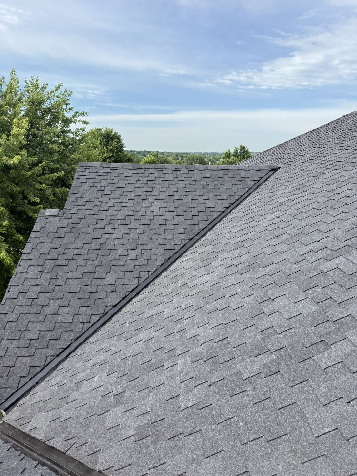 Dark architectural shingle roof with a metal valley on a Bellevue home inspected by Royalty Roofing