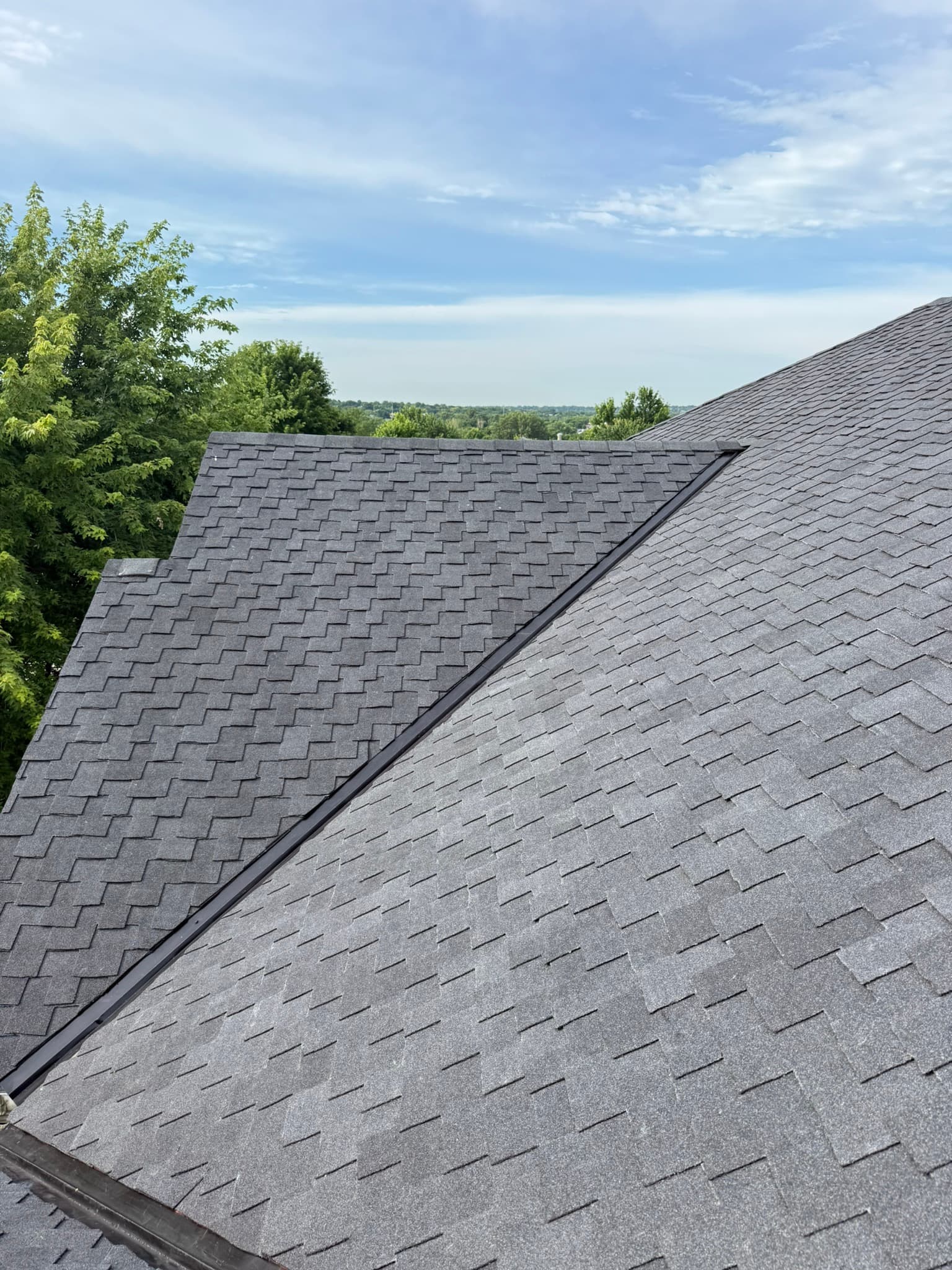 Dark architectural shingle roof with a metal valley on a Bellevue home inspected by Royalty Roofing