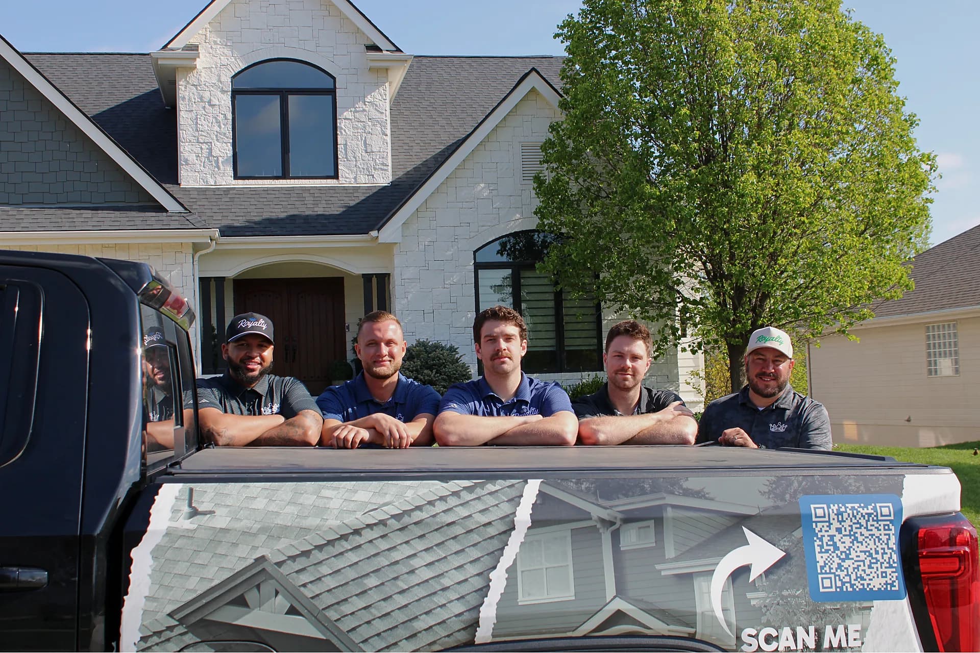 Royalty Roofing team members by a company truck