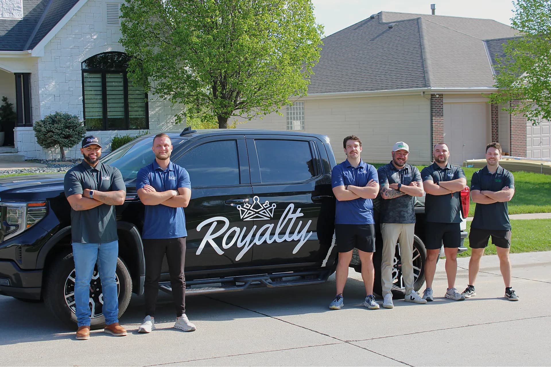 The Royalty Roofing team in front of a branded company truck