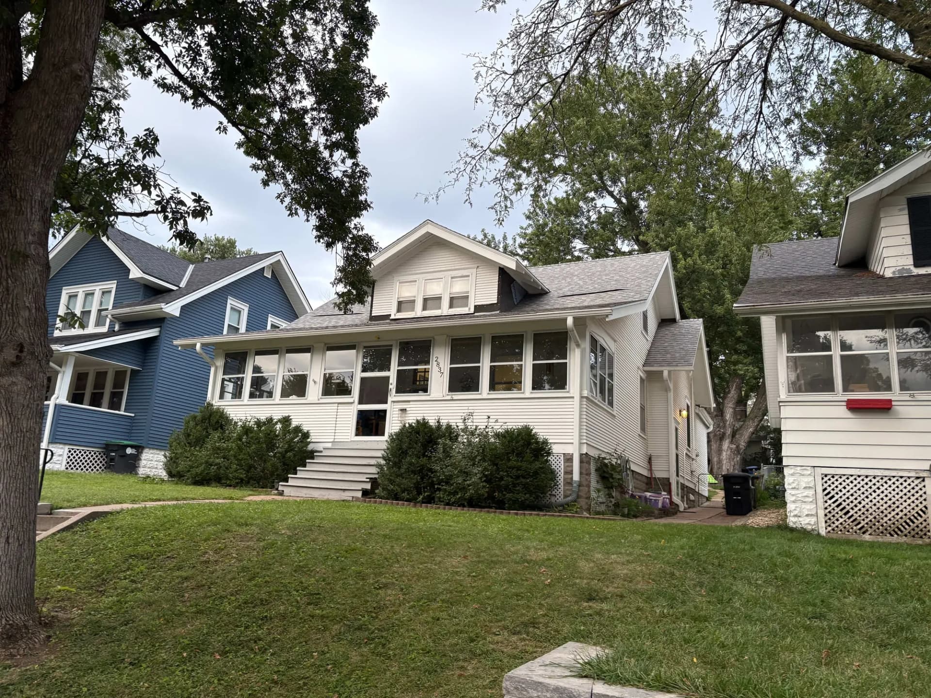 Craftsman bungalow with a shingle roof and enclosed front porch in Midtown Omaha