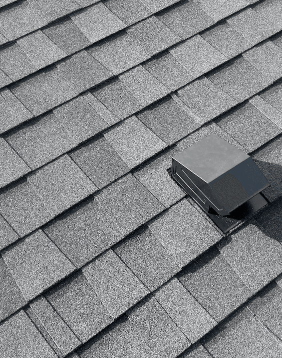 Close-up of a black roof vent sealed into gray architectural shingles on a Ralston home
