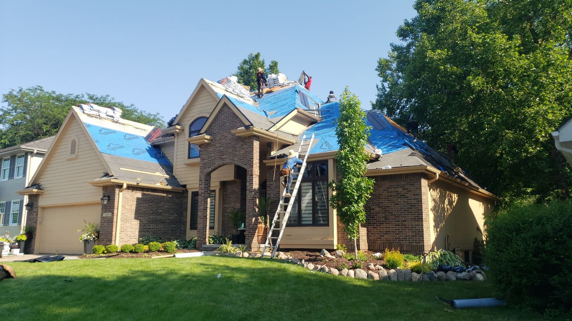 Royalty Roofing crew working on the roof of an Omaha-area brick home