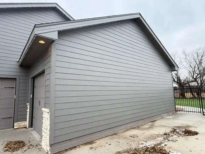 Gray fiber cement lap siding with stone accent on an Omaha home